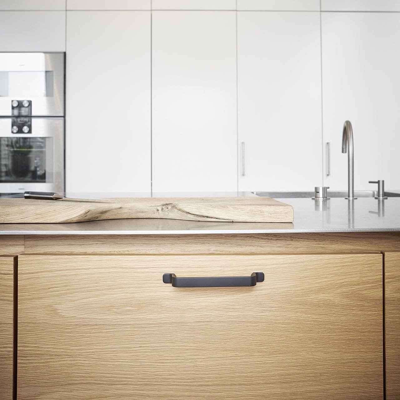 Zdjęcie przedstawia uchwyt meblowy podłużny z serii Rio na meblu od Beslag Design