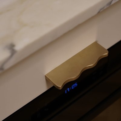 Elongated furniture handle, wavy, 13 120, brass, polished