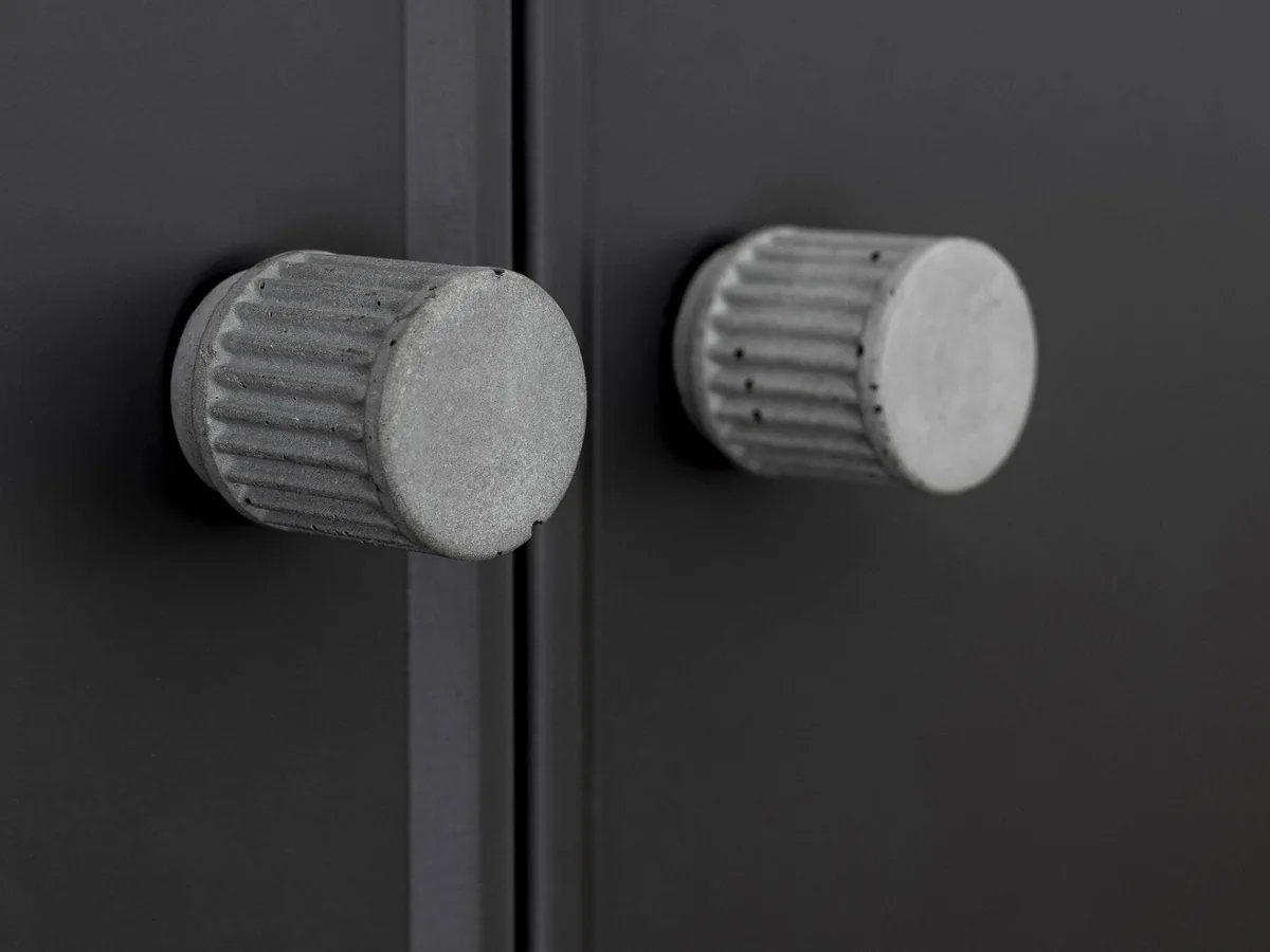 Concrete knobs on black cabinet doors